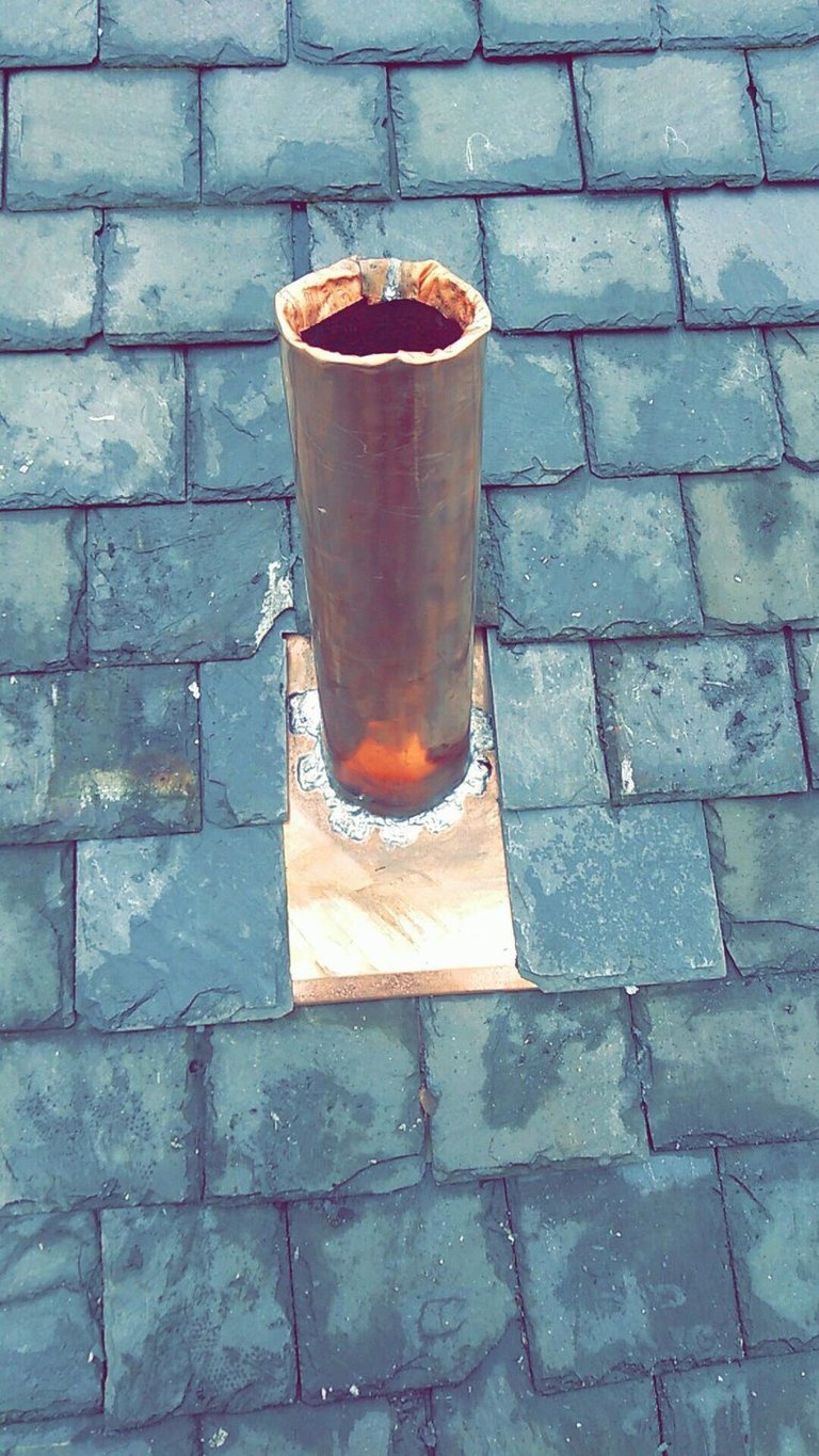 Copper vent pipe boot sealed into a slate roof