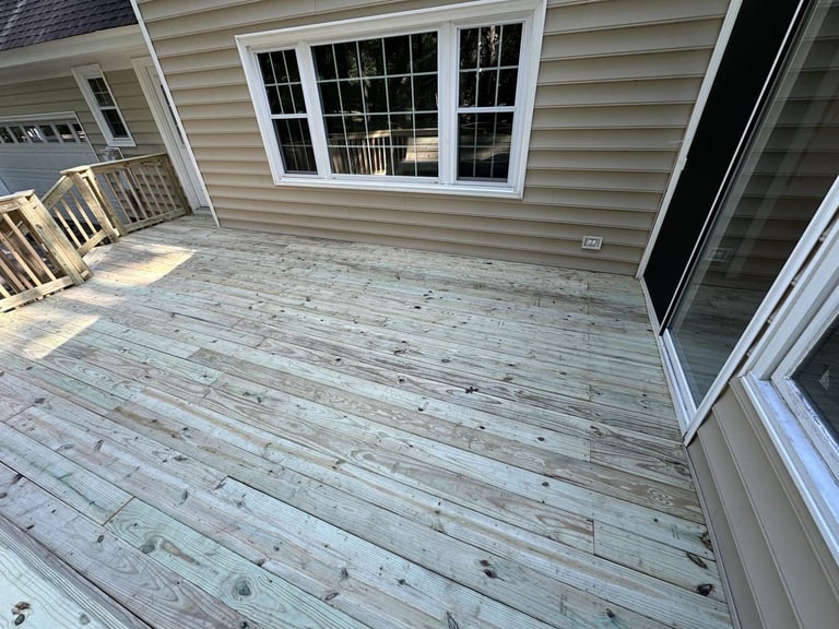 Pressure-treated deck replacement with white railings and a bay window, Richmond VA area