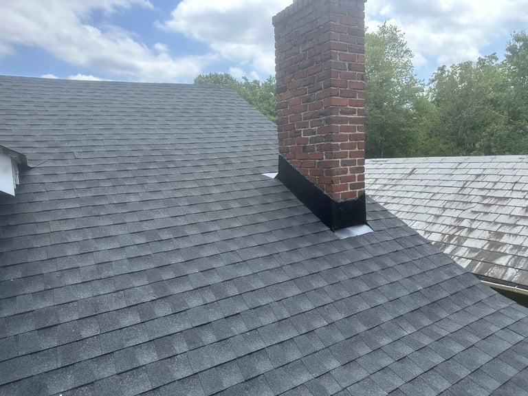 Brick chimney with new black flashing on a shingle roof