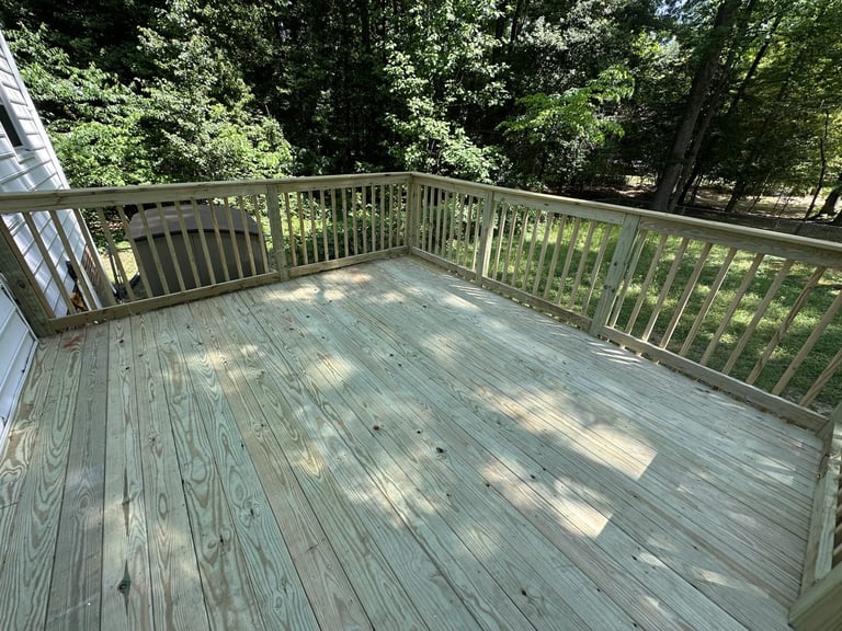 Pressure-treated deck replacement with railings overlooking green trees, Richmond VA area